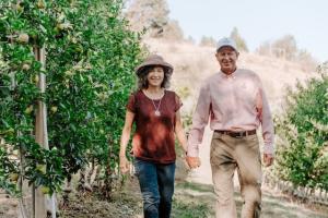 Neal and Louisa Carter walking in Arctic apple orchard