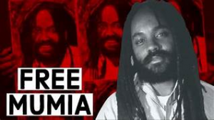 Mumia is smiling in the foreground and there are three images of Mumia in red in the background