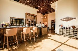 Reception area inside a The Gents Place club featuring a concierge desk, member bar, retail displays, and upscale interior finishes.