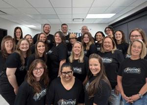 Journey Payroll & HR team members smiling together at the 2026 Annual Conference, wearing matching Journey-branded shirts, representing the locally owned payroll and HR company serving businesses across all 50 states.