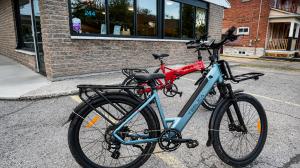 Blue step-through and red folding Teslica electric bikes displayed outside the Teslica location in Ottawa, Ontario.