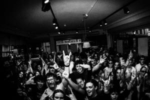 A tight and sweaty crowd raising their hands to the camera during the first installment of Tomorrow's Tracks in Soho, London.