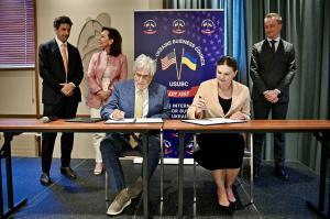 Jim Berlin (left) signing the MOU with Oleksii Sobolev (right) as a witness.