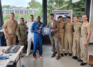 U.S. Navy Capt. Victor Glover, center, stands with Naval Postgraduate School students, faculty, and staff from the Space Systems Academic Group following a series of research briefings from current students and a tour of the school’s small satellite laboratory.