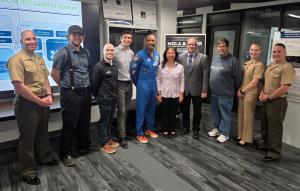 Naval Postgraduate School graduate U.S. Navy Capt. Victor Glover, center, stands with students, faculty, and staff from the Space Systems Academic Group following a series of research briefings.