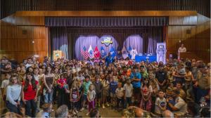 Following his presentation to a packed King Hall at the Naval Postgraduate School (NPS), NASA Artemis II pilot U.S. Navy Capt. Victor Glover welcomed a sea of youngsters to the front of the auditorium for a group photo.