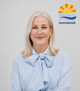 Sally Ferguson, executive director of Sunnybrook Children’s Home, seated in front of the Sunnybrook logo.