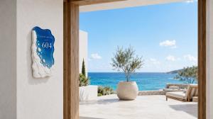 A luxury outdoor resort villa room sign mounted on a white textured wall. The sign combines deep sea-blue translucent dyed acrylic with a rugged, white stone-like frame texture on the left, displaying white lettering "COAST HOUSE" and "604" overlooking a