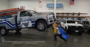 Vortex Doors technician wearing a superhero cape and eye mask while “lifitng” a Vortex vehicle. This image was enhanced using artificial intelligence (AI). It does not depict an actual worksite, job activity, or recommended safety practices.