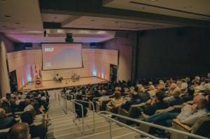 A wide view of attendees at the Arizona District Export Council's inaugural North American Exceptionalism Forum at the Phoenix Art Museum, with Chair Carol Colombo and Canadian Ambassador Mark D. Wiseman seated on stage.
