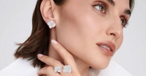 Close-up of Piranesi Fiore Collection diamond flower earrings and matching diamond flower rings crafted in luxurious Italian fine jewelry with the signature four-petal floral motif.