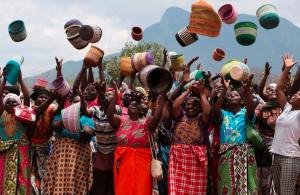 Women basket weavers tossing their baskets in the air. These women are part of Hadithi Crafts Support, a community-based organization.