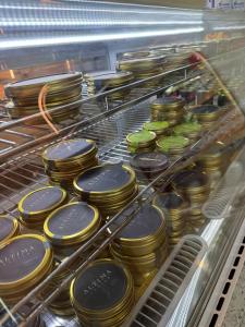 Altima Caviar tins displayed in a refrigerated retail case at Fiora’s Bottle Shop in Houston
