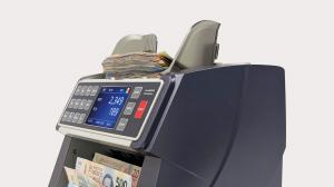 Close-up view of the AccuBANKER AB7100 ValuePro cash counter connected to an MP20 thermal receipt printer showing a printed cash verification report.