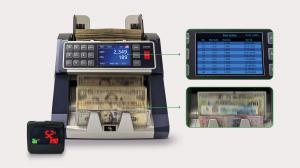 AccuBANKER AB7100 ValuePro automatic money counting machine operating on a retail store checkout counter next to stacks of cash bills.