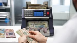 Front profile view of the AccuBANKER AB7100 ValuePro mixed bill value counter with digital touch screen display showing cash total breakdown on a white background.