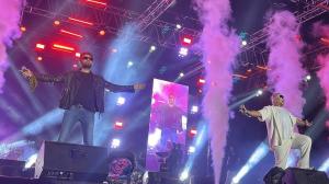 Vishal & Sheykhar performing on stage with lights, smoke effects, and large-scale concert production for “The Superhit Tour,” supported in select markets by Kash Patel Productions.