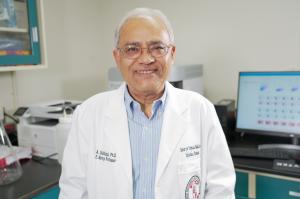 Dr. Afzal Siddiqui, Ph.D., standing in his laboratory where he conducts vaccine research.