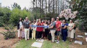 Family Hospice leaders, employees, and Henry County Chamber of Commerce representatives participate in a ribbon-cutting ceremony outside the new McDonough Inpatient Unit in McDonough, Georgia.