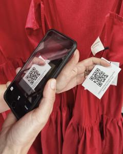 Customer scanning the QR code on a Mystic Moods dress to access the Garment Journey App.