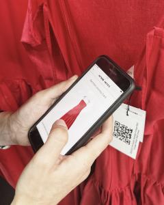 Garment Journey App displayed on a smartphone after scanning a QR code on a Mystic Moods dress.