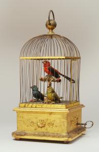 Image of mechanical birds in a gilded cage.