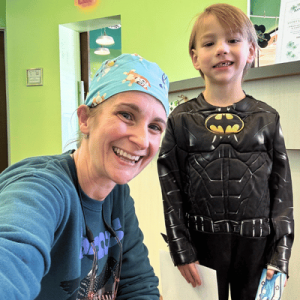 Dr. Mindi D'Elia with a young boy wearing a Batman costume.