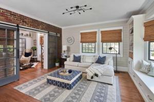 ReVision Design + Build's two-story historic home addition in Plaza Midwood, Charlotte, features a farmhouse-inspired aesthetic with shiplap walls and a neutral palette, seamlessly blending new construction with the original architecture.