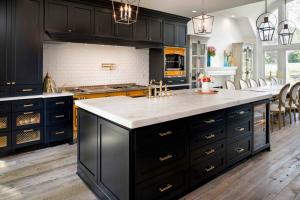 Luxury custom kitchen remodel by ReVision Design + Build featuring navy cabinetry, a marble island, and a yellow La Cornue range.