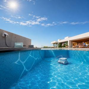 CHASING Hydro4 corded robotic pool cleaner working underwater in a residential swimming pool, connected by cable to a poolside power unit to showcase stable power and ready-to-clean performance.