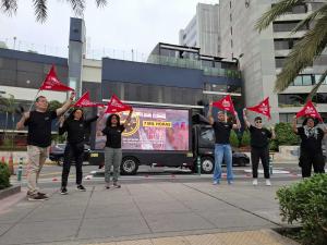Activistas de la OWA protestan contra Vivanda en Lima usando banderas rojas.