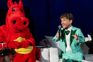 LuskinOIC mascot, Ozzie The Dragon and Innovation + Access Gala Emcee, Nic Novicki chat on stage