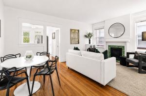 Professionally staged living and dining room designed by Jsquared Interior Staging & Design with contemporary furnishings, hardwood floors, original historic fireplace, and abundant natural light.
