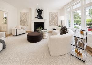 Open-concept luxury living room staged with boucle seating, oversized area rug, abstract artwork, black fireplace, and contemporary designer décor in Richmond, Virginia.