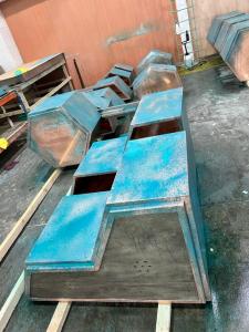 Handmade copper garden containers set up in Halman Thompson's workshop during the bespoke hand-ageing process