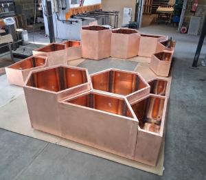 Handmade copper garden containers set up in Halman Thompson's workshop before the bespoke weathering process