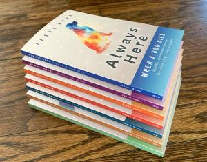 Stack of seven Always Here grief companion books by Jesse Kuhn covering spouse loss, pet loss, relationship loss, disenfranchised grief, and widowed parenting.