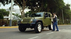A girl smiling entering a green Jeep