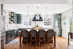 Renovated kitchen with green shaker cabinets, white subway tile, and hardwood floors — Montgomery County, MD remodel by Think2Remodel.