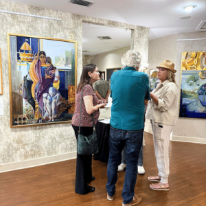 Visitors view artwork and speak with a staff member during a gallery experience at First Coast Cultural Center.
