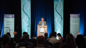 Jeremy Kelly speaks from a podium during a Myotonic Dystrophy Foundation conference.
