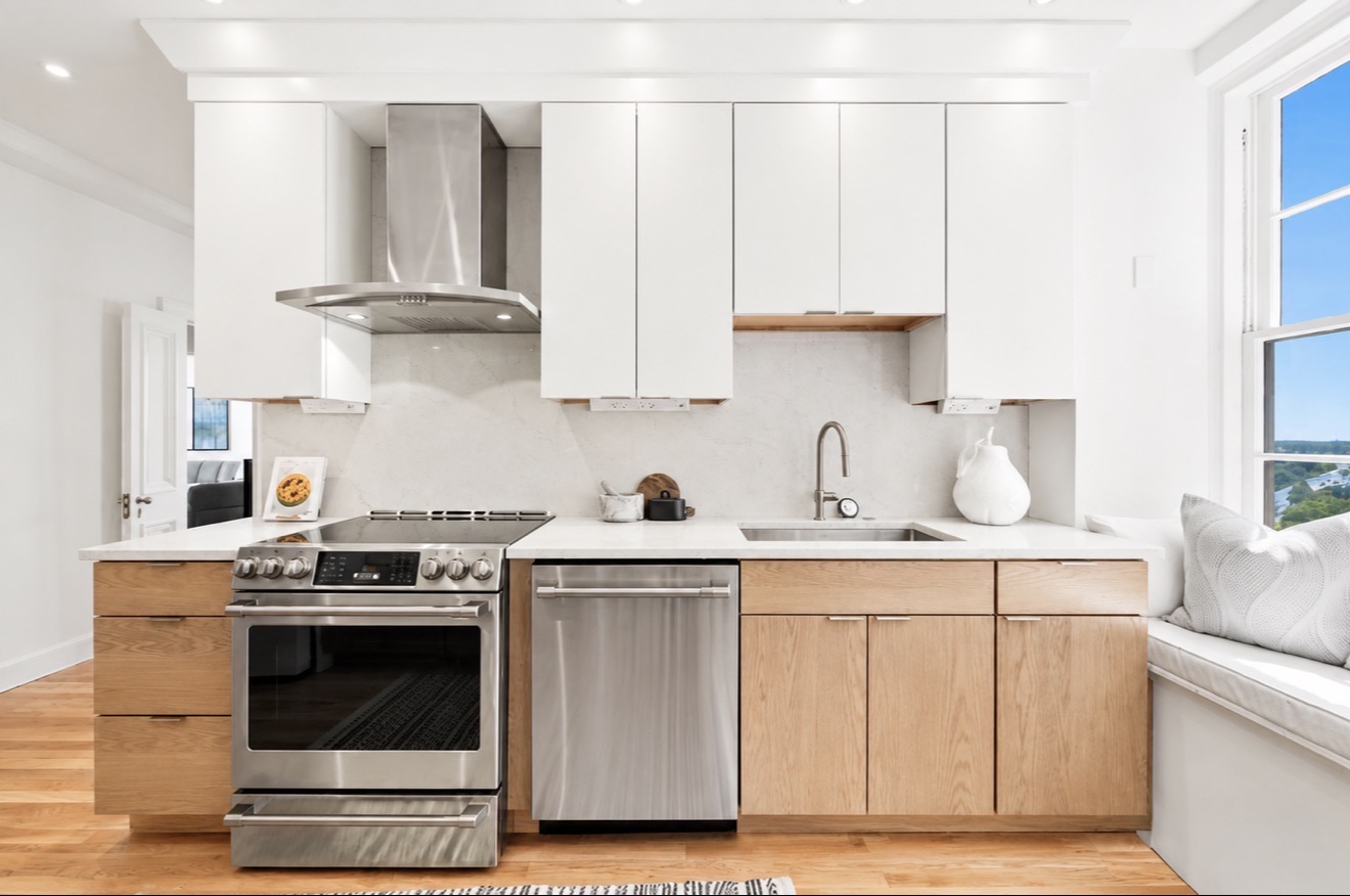 Renovated kitchen in Prestwould condominium Unit 9D Richmond VA with quartz countertops, stainless Café appliances, white and oak cabinetry, and window seat