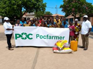 Pocfarmer representatives stand with children behind a Pocfarmer banner after donating food and essential supplies during a charity outreach event in Africa.