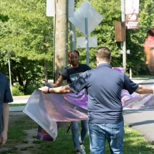 Artist Nile Livingston helps carry and install a mural panel for the "Echoes Beyond the Stage" public art installation at the Highmark Mann Center for the Performing Arts in Philadelphia