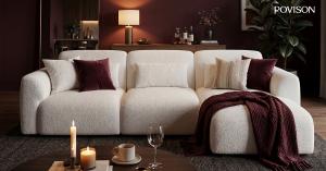 POVISON Aurora Power Sofa Bed with an extended chaise, burgundy throw, and candles in a warm living room.