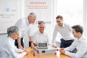 The five members of the Securosys management team gathered around Securosys hardware security modules (HSMs) during a meeting. From left to right: Andreas Curiger (CTO/CSO), Robert Rogenmoser (CEO), Marcel Dasen (Executive VP Engineering), Reto Stäuble (Execu