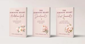 Three pastel pink books from The Feminine Heart series by Laura Anthony, LCSW, standing side by side against a soft neutral background. The covers feature elegant floral illustrations and gold accents. The titles are Meditation Guide, Devotional, and Rese