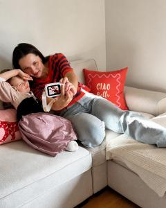 a girl sitting on the sofa with her mom, they are using Dr.Look Ai learning camera together