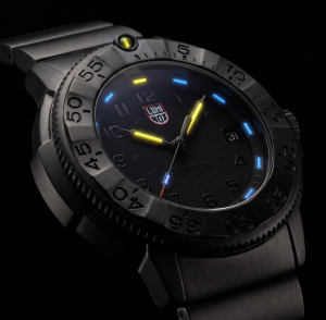 Luminox Navy SEAL Foundation XS.3228.NSF with glowing LLT illumination on a blackout dial and IP Gun stainless steel bezel.