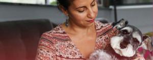Jo Cooper is holding her miniature schnauzer pet, Angus.